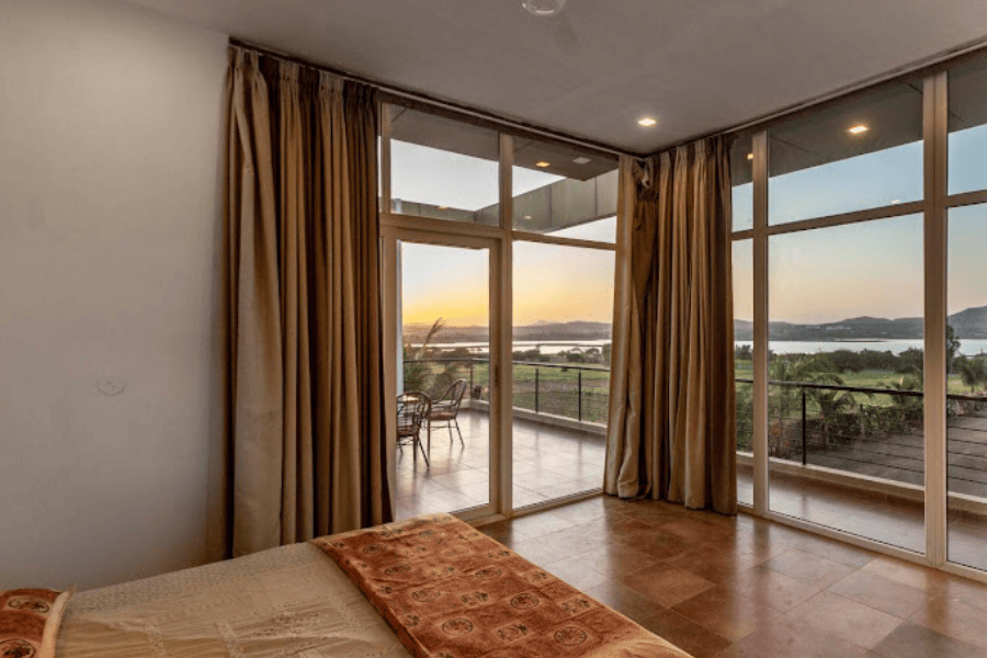 Lake view villa Nashik bedroom with balcony and sunrise view for peaceful mornings