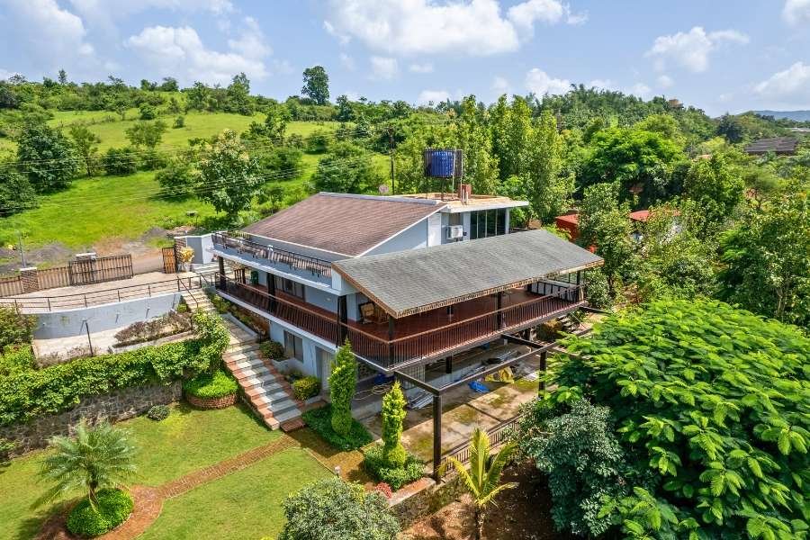 Spacious hilltop villa surrounded by lush greenery with scenic views and a large garden in Nashik.