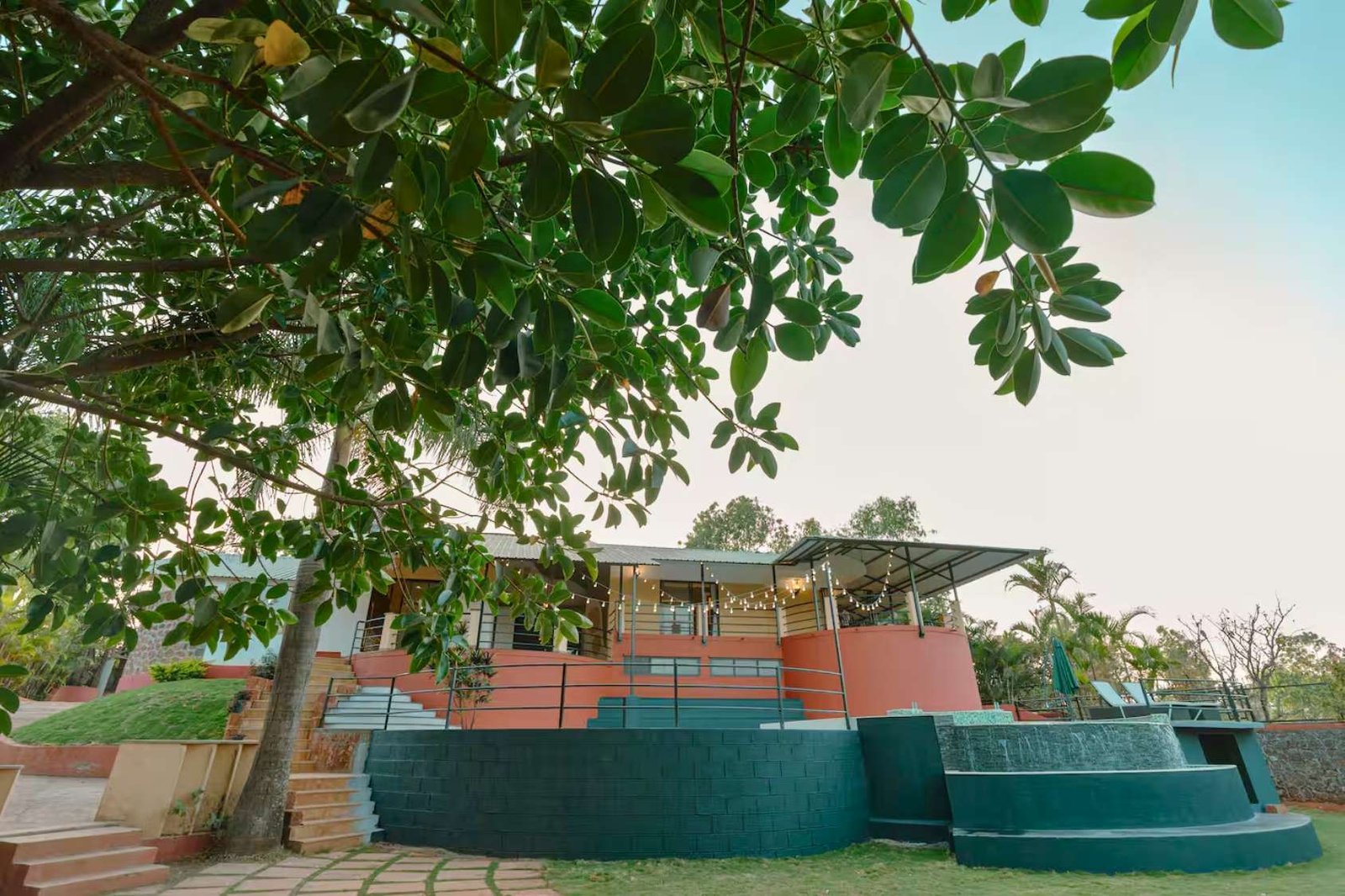 Modern villa in Panchgani, with expansive lawn, outdoor seating, and scenic views.