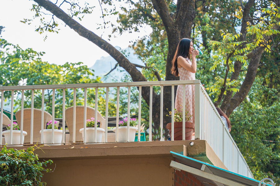 Traveler enjoying peaceful solitude and mountain views from a villa terrace.
